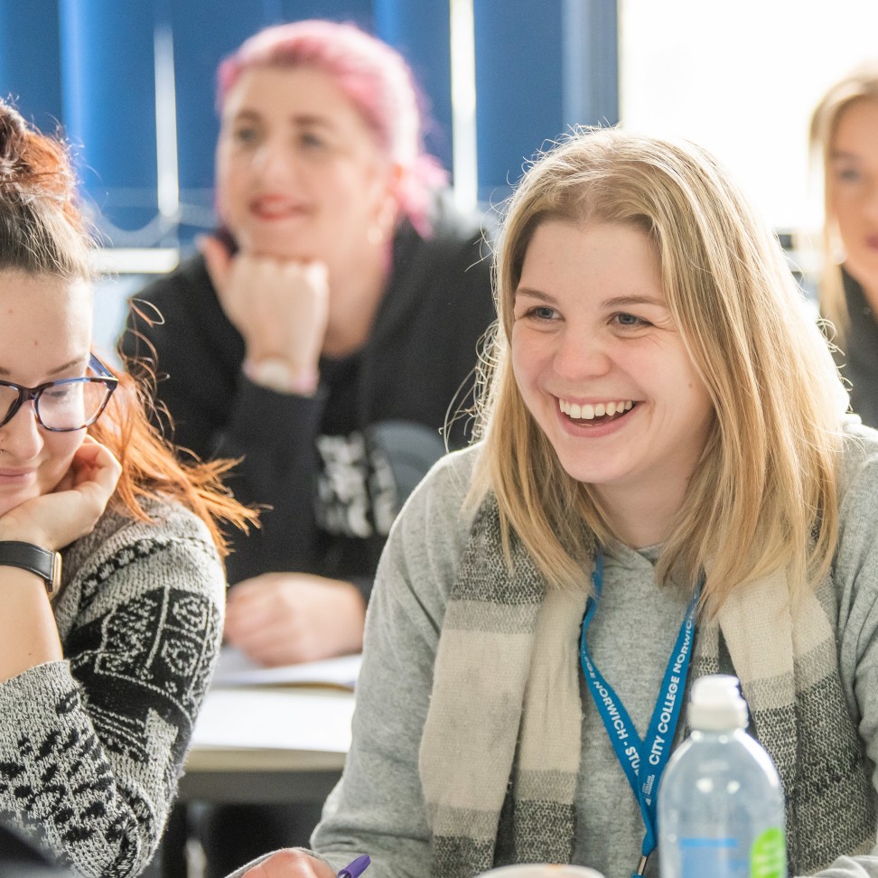 Two students sat at a table, both smiling.