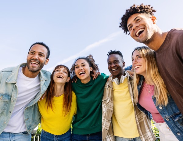 A group of Youth Work students are huddling in a group, smiling.