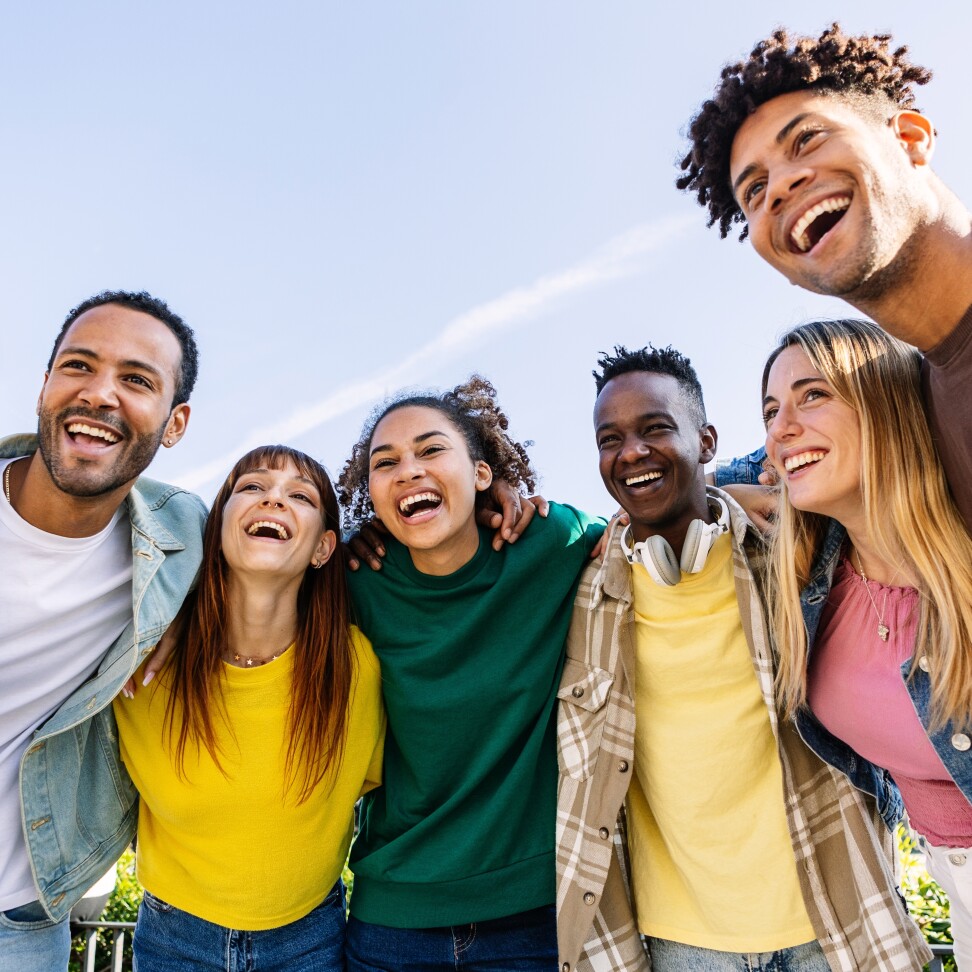 A group of Youth Work students are huddling in a group, smiling.