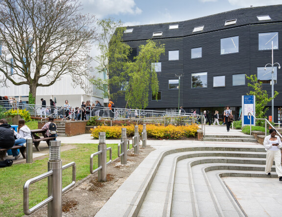 City College Norwich campus. Bustling with students outside, and with a view of the Creative Arts building.