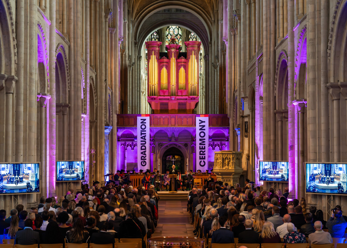 The graduation ceremony, showing the audience from the back, and the stage.